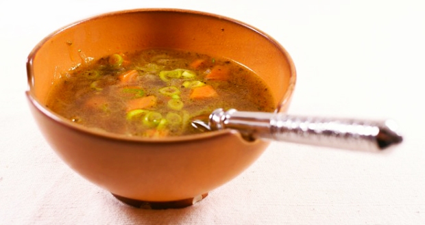 Ribollita mit Olivenblätter in einer Suppenschale serviert. Diese leckere Resteverwertung wird, durch die Verwendung von Olivenblättern mit ihren würzigen Geschmack und gesundheitsfördernden Eigenschaften, in aussergewöhnlicher Weise „aufgepimpt“.
